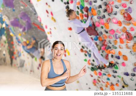 Young woman posing on climbing wall Young woman posing on climbing wall 135111688