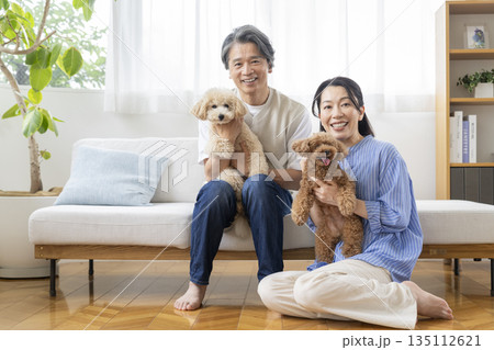 カメラ目線で笑顔の50代の夫婦と愛犬 犬との暮らしイメージ カメラ目線で笑顔の50代の夫婦と愛犬 犬との暮らしイメージ 135112621