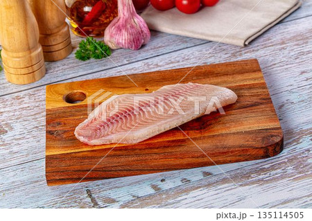 Raw tilapia fish fillet over board Raw tilapia fish fillet over board 135114505