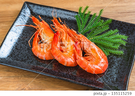 黒い角皿に盛られた茹で海老 135115259