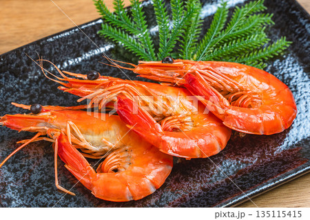 黒い角皿に盛られた茹で海老 135115415