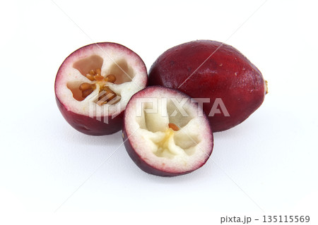 Whole and halved cranberries showing their juicy interior with seeds on a clean white background 135115569