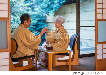 旅館の縁側で乾杯をするシニア夫婦　撮影協力:伊東緑涌 135115596