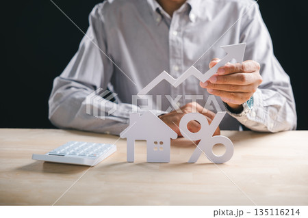 Person evaluates house property market, holding rising arrow showing growth, assessing real estate mortgage interest rates and loan percentage for successful investment 135116214