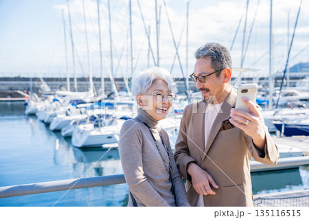 港で自撮りをするシニア夫婦 撮影協力:道の駅伊東マリンタウン 港で自撮りをするシニア夫婦 撮影協力:道の駅伊東マリンタウン 135116515