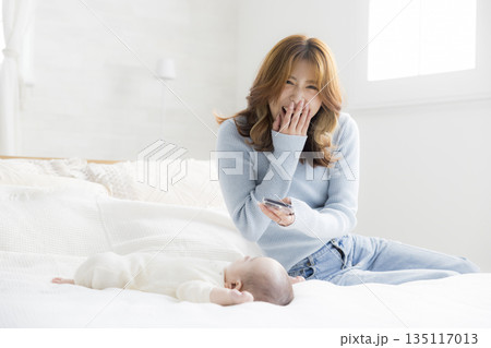 赤ちゃんをスマホで撮る若い母親 赤ちゃんをスマホで撮る若い母親 135117013
