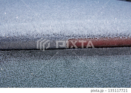 Ice frozen on the roof and window of a car Ice frozen on the roof and window of a car 135117721