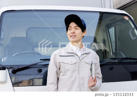 トラックの前で見上げるデリバリースタッフ 135118333