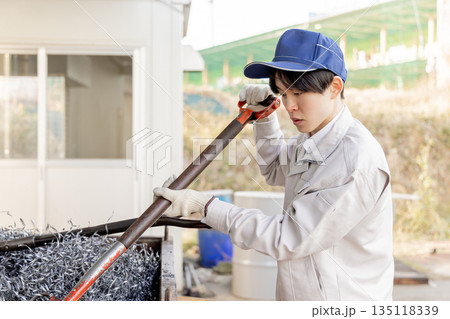 金属の廃材を片付ける男性作業員 金属の廃材を片付ける男性作業員 135118339