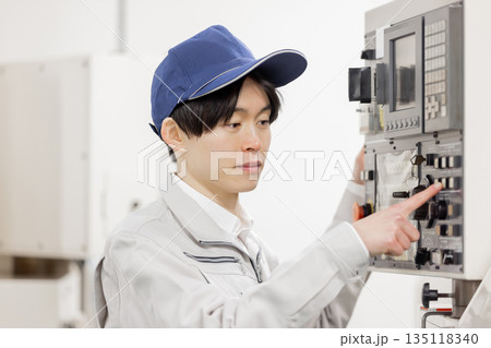 工場の操作盤の前で働く男性作業員 135118340