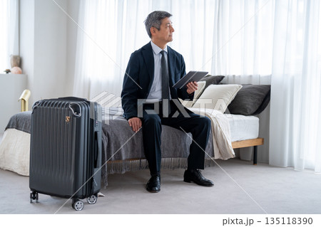 旅行や出張で宿泊施設を利用するシニア男性 135118390