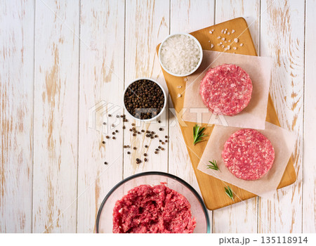 homemade burger beef patties on a white wooden table , top view. 135118914