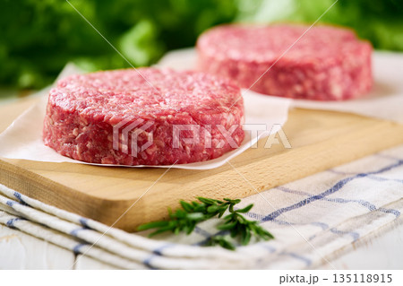 Raw burger beef patties on a white table, selective focus..Raw minced beef patties for burgers. Raw burger beef patties on a white table, selective focus..Raw minced beef patties for burgers. 135118915