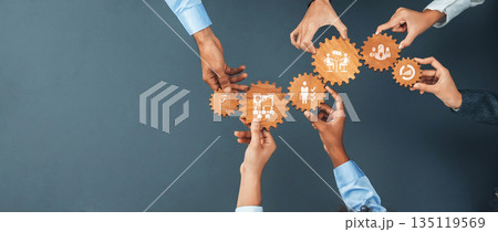 Collaborative Business Management Concept with Diverse Team Members Aligning Gears Symbolizing Strategy, Efficiency, and Teamwork in Modern Workplace. Amity Collaborative Business Management Concept with Diverse Team Members Aligning Gears Symbolizing Strategy, Efficiency, and Teamwork in Modern Workplace. Amity 135119569