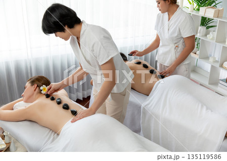 Hot stone massage at spa salon in luxury resort. Quiescent Hot stone massage at spa salon in luxury resort. Quiescent 135119586