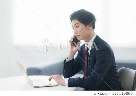 スマホで通話する若いビジネスマン スマホで通話する若いビジネスマン 135119866