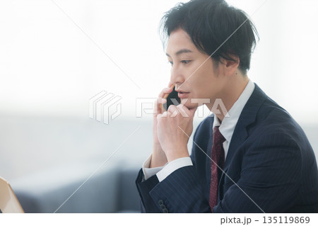 スマホで通話する若いビジネスマン 135119869