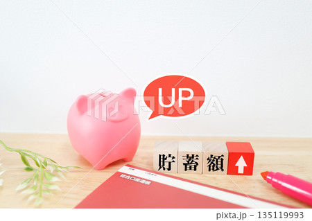 通帳と貯金箱で表現する貯蓄額アップのイメージ。 135119993