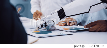 Robotic Arm Analyzing Financial Charts and Graphs During Corporate Meeting Featuring Business Professionals in Modern Office Environment. Noogenesis Robotic Arm Analyzing Financial Charts and Graphs During Corporate Meeting Featuring Business Professionals in Modern Office Environment. Noogenesis 135120193