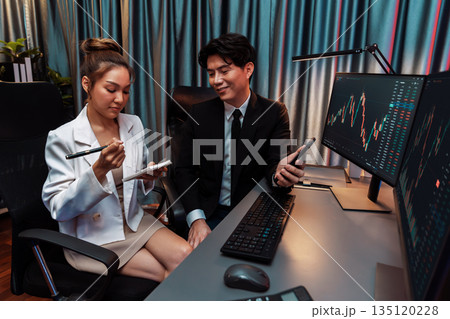 Businessman showing stock on phone to partner pointing at neon night. Infobahn. Businessman showing stock on phone to partner pointing at neon night. Infobahn. 135120228