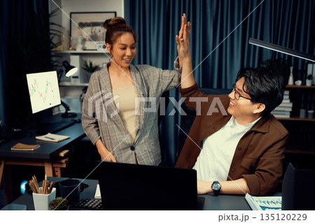 Smiling business trader with partner in casual suit taking high five. Infobahn. Smiling business trader with partner in casual suit taking high five. Infobahn. 135120229
