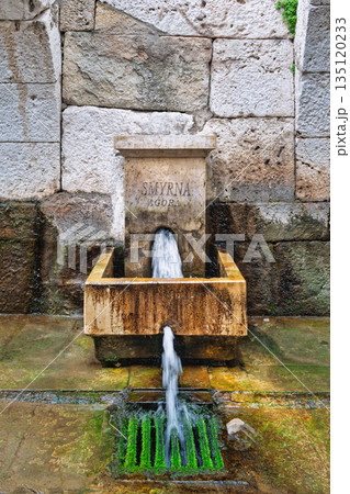 Ancient stone fountain with Smyrna Agora inscription at Izmir Agora Open Air Museum, Izmir, Turkey. Ancient stone fountain with Smyrna Agora inscription at Izmir Agora Open Air Museum, Izmir, Turkey. 135120233