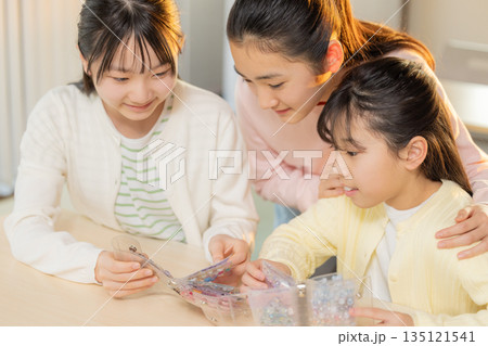 放課後に小学生の女の子がシール帳を使ってシール交換を楽しむ様子 135121541