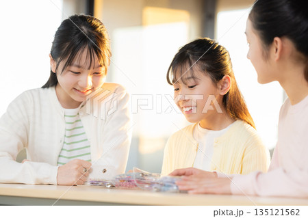 放課後に小学生の女の子がシール帳を使ってシール交換を楽しむ様子 135121562