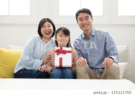 プレゼントを手に喜ぶ3人家族 135121705