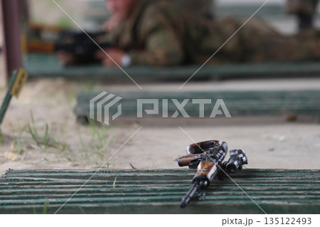 Close-up of a Kalashnikov assault rifle against the background of firing soldiers 135122493