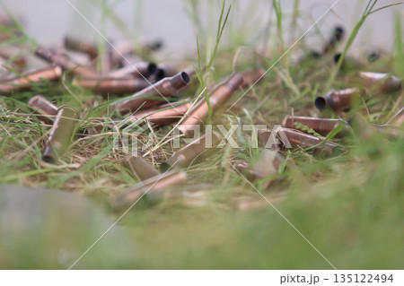 bullet shells ground. Cases of bullets lying on the floor of artificial grass 135122494