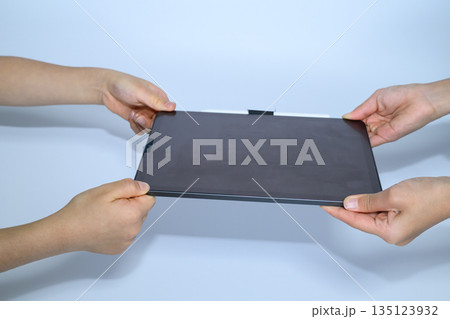 タブレット端末を奪い合う子供の手 タブレット端末を奪い合う子供の手 135123932