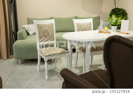 Cozy living room with green sofa and elegant dining set 135127919