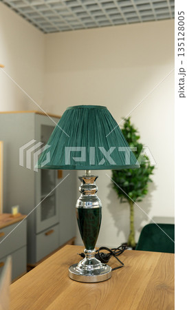 Elegant green lampshade on silver base in cozy home interior setting Elegant green lampshade on silver base in cozy home interior setting 135128005