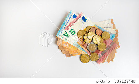 Euro banknotes and coins on white background with copy space. Euro banknotes and coins on white background with copy space. 135128449