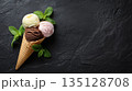 Three flavor ice cream cone with mint leaves on black slate background 135128708