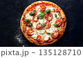 Traditional Margherita pizza with tomatoes, mozzarella and basil on dark background 135128710