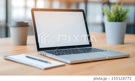 Modern Workspace with Laptop, Notebook, Coffee Cup, and Plant on Wooden Table Surface 135128772