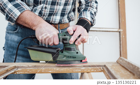 Carpenter at work, restoring an old wooden window. Carpentry. 135130221