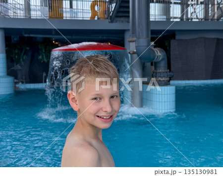 Happy teenage boy enjoying swimming pool fun at a water park on a sunny day Happy teenage boy enjoying swimming pool fun at a water park on a sunny day 135130981