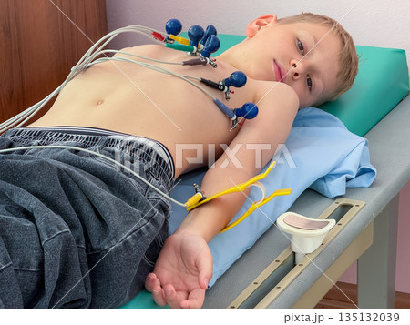 Child undergoing electrocardiogram examination in medical clinic 135132039