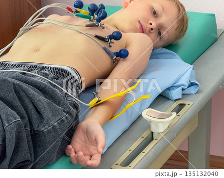 Child undergoing electrocardiogram examination in medical clinic 135132040