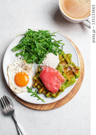 Healthy breakfast with green spinach waffles, salmon, cream cheese, fried egg and salad Healthy breakfast with green spinach waffles, salmon, cream cheese, fried egg and salad 135133665