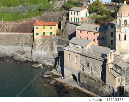 View of Vernazza, a town in Cinque Terre, from the mountain. Nature and sea, traditional buildings of Liguria, Italy. Architecture protected by UNESCO. Church of Santa Margherita. 135133734