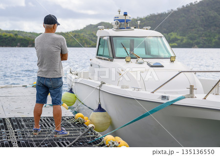 男性と係留されたボート 【撮影協力：隠岐シーサイドリゾートみやび様】 135136550