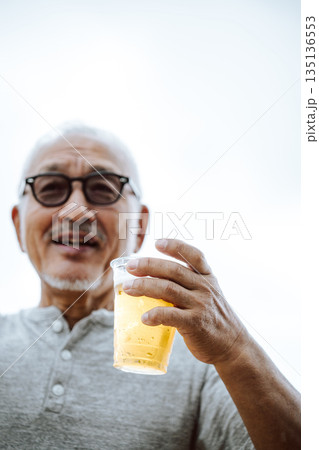 男性がビールを持つ 【撮影協力：隠岐シーサイドリゾートみやび様】 135136553