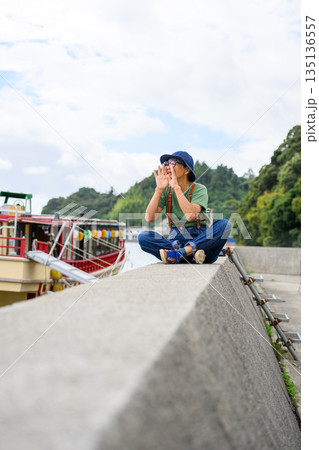 堤防で叫ぶ高齢者 【撮影協力：隠岐シーサイドリゾートみやび様】 135136557