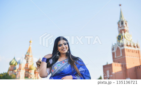 Bangladeshi woman smiling in blue sari in front of Saint Basil's Cathedral, Moscow 135136721