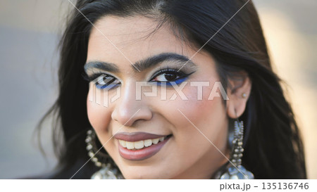 Young Indian woman with blue eye makeup looking at camera 135136746