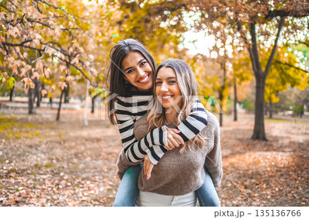 Two Women Hugging Each Other in a Park 135136766